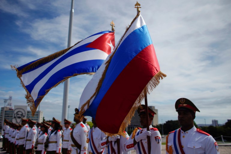 Honor guards hold a Russian and a Cuban flag during a wreath-laying ceremony with Russia's Prime Minister Dmitry Medvedev (not pictured) at the Jose Marti monument in Havana, Cuba, October 3, 2019. REUTERS/Alexandre Meneghini