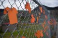 Orange shirts line a fence outside a former residential school in Canada