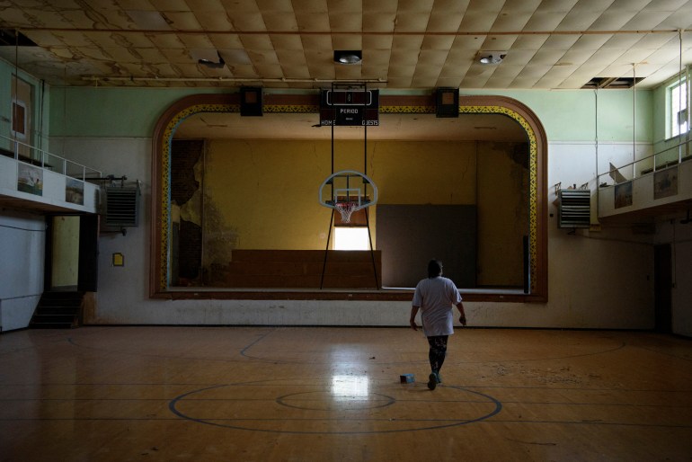 Una persona camina por un gimnasio abandonado que solía ser parte de la antigua Escuela de la Misión India de St. Paul durante un recorrido por los terrenos de la escuela en Marty, Dakota del Sur, EE. UU.