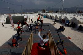 Children play at a playground in Orhanli tent city in the aftermath of a deadly earthquake, in Antakya, Hatay province, Turkey, March 3, 2023 [Susana Vera/Reuters]