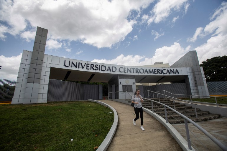 A woman leaves the Jesuit Central American University (UCA) in Managua, Nicaragua August 16, 2023. An entry way with the school's name can be seen behind her.