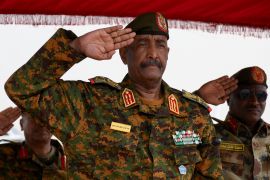 General Abdel Fattah al-Burhan salutes as he listens to the national anthem after landing at a military airport in Port Sudan [File: Ibrahim Mohammed Ishak/Reuters]