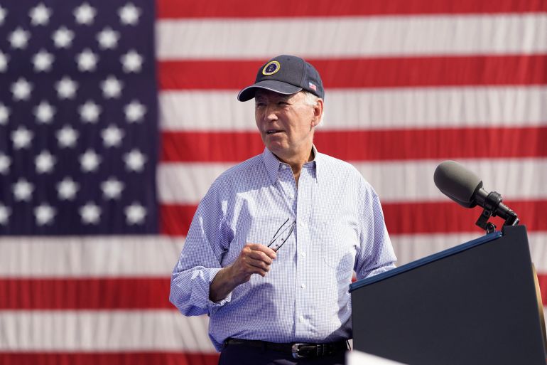 Joe Biden ABD bayrağının önünde duruyor
