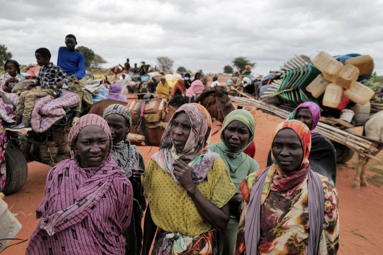 Sudanese women, who fled the conflict in Murnei in Sudan's Darfur region, wait beside their belongings to be registered by UNHCR upon crossing the border between Sudan and Chad