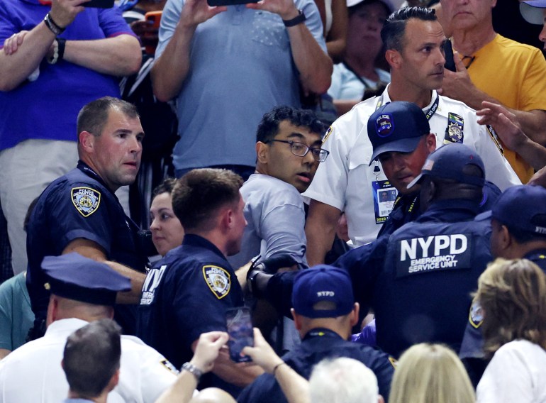 A demonstrator is being removed from the stadium by New York City Police Department (NYPD) officers during the semi final match between Czech Republic's Karolina Muchova and Coco Gauff of the U.S. 