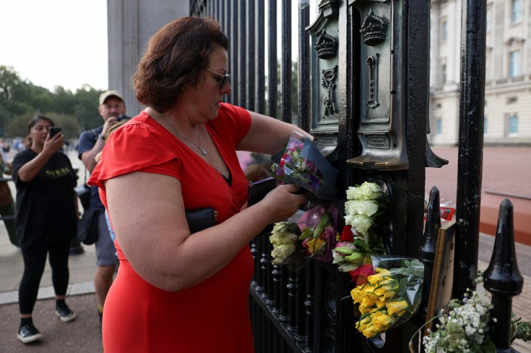 Arlene Winter from the Cotswolds lays flowers outside the Buckingham Palace on the first anniversary of Queen Elizabeth II's death, in London