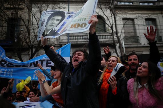 Argentine presidential candidate Javier Milei for La Libertad Avanza coalition holds a placard depicting a dollar bill with his face, during a campaign rally in La Plata, Buenos Aires, Argentina, September 12, 2023.