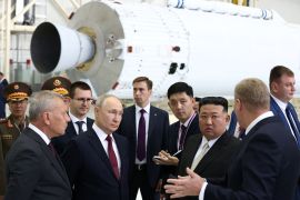 Putin and Kim touring the Vostochny Cosmodrome. Kim is listening to an official, Putin is watching.