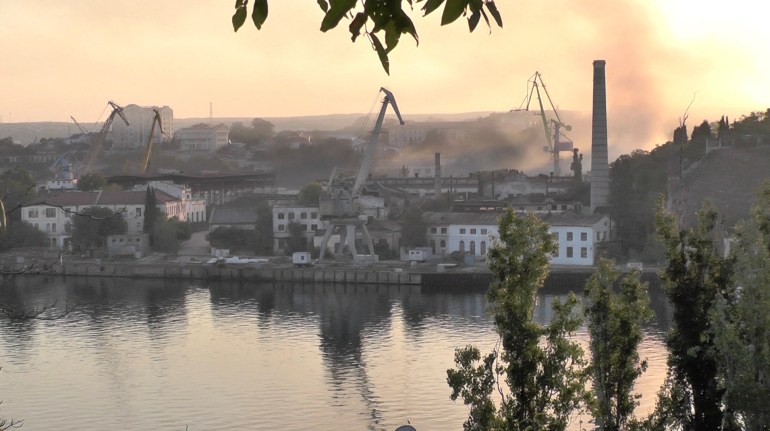 Smoke rises from the shipyard in Crimea after a Ukrainian attack