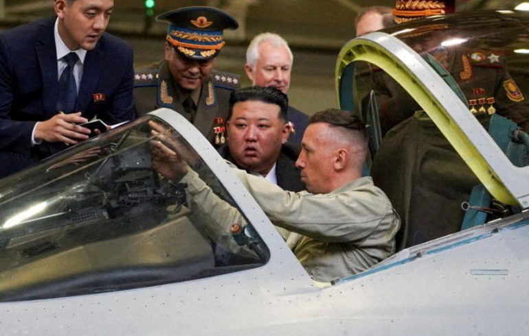Il leader nordcoreano Kim Jong Un controlla un aereo da caccia russo.  I piloti nella cabina di pilotaggio e fanno notare le cose a Kim