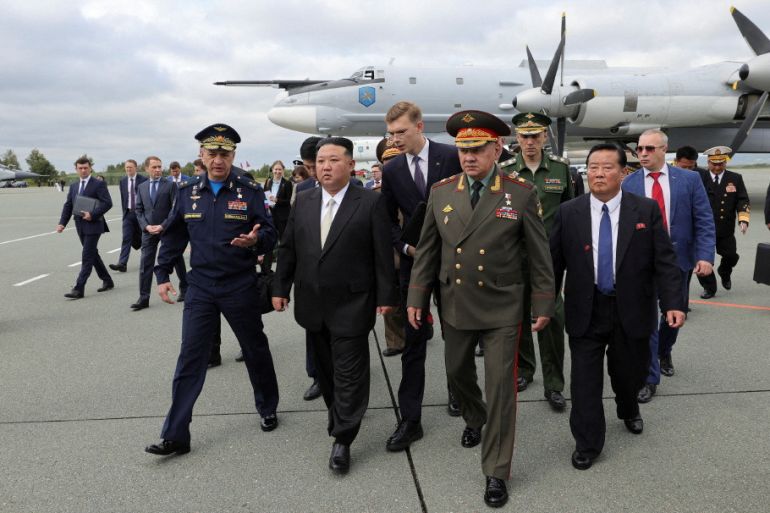 Kuzey Kore lideri Kim Jong Un (ortada) ve Rusya Savunma Bakanı Sergei Shoigu (sağda), 16 Eylül 2023'te Rusya'nın Primorsky bölgesindeki Vladivostok yakınlarındaki Knevichi havaalanında sergilenen Rus askeri uçaklarını ve füzelerini inceliyor. [Russian Defence Ministry/handout via Reuters]