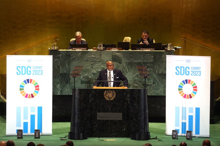 Dennis Francis stands at the UN podium between two signs that read "SDG," an acronym for the Sustainable Development Goals.