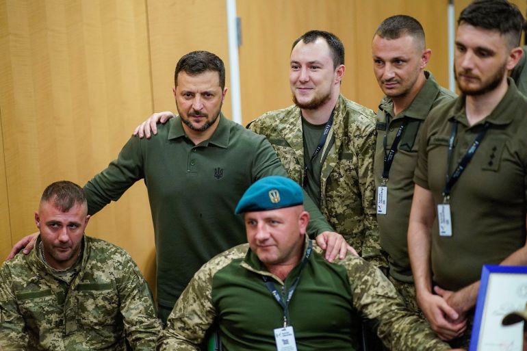 Ukrainian President Volodymyr Zelenskyy poses for a photo with soldiers receiving treatment for injuries in the US