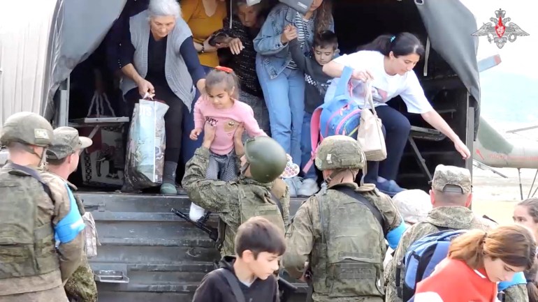 Russian troops assist civilians during evacuation at an unknown location in Nagorno-Karabakh before a truce was declared on Wednesday. (Russian Defence Ministry/Handout via Reuters)