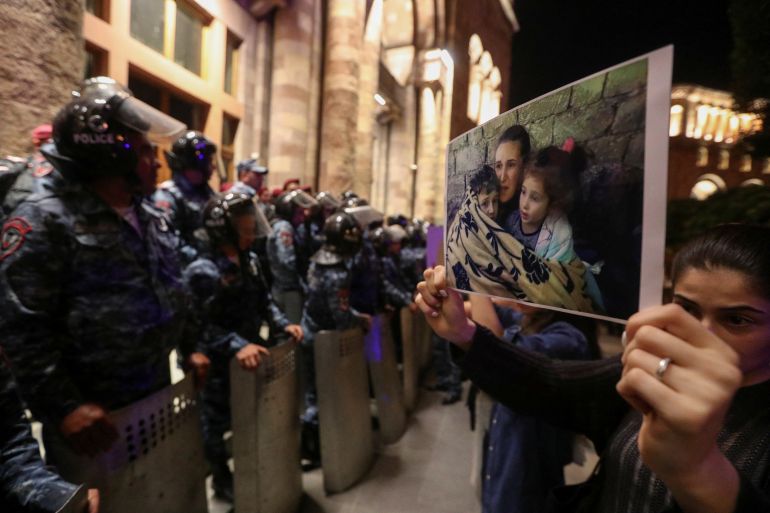 A protester shows a photograph near the government building during a rally to support ethnic Armenians in Nagorno-Karabakh