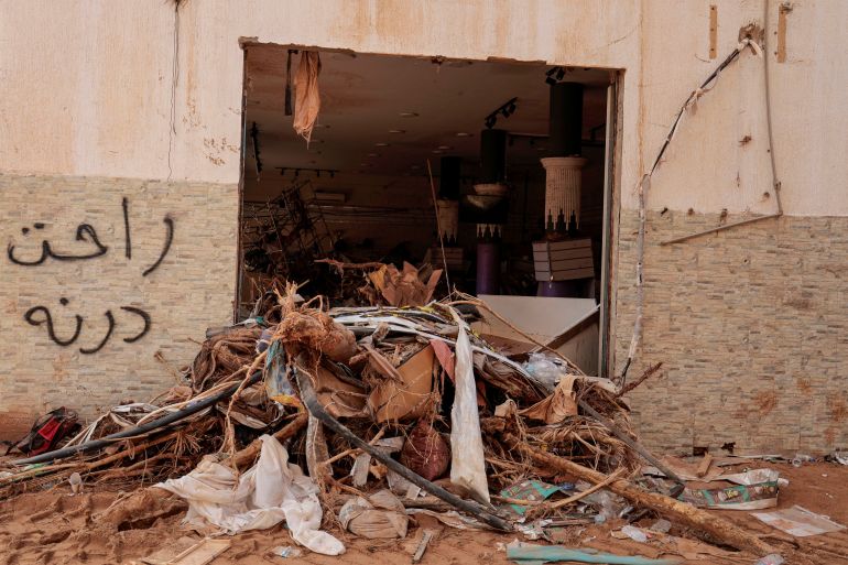Graffiti que diz "Derna se foi" é visto na parede de uma loja danificada após a tempestade mortal que atingiu a Líbia, em Derna, Líbia, em 21 de setembro de 2023.
