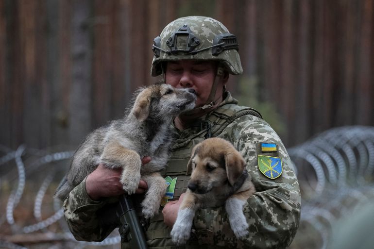 Serhiy Nayev Commander of the Joint Forces of the Armed Forces of Ukraine on a visit to positions near the border with Belarus. He is in combat uniform and carrying a puppy in each arm