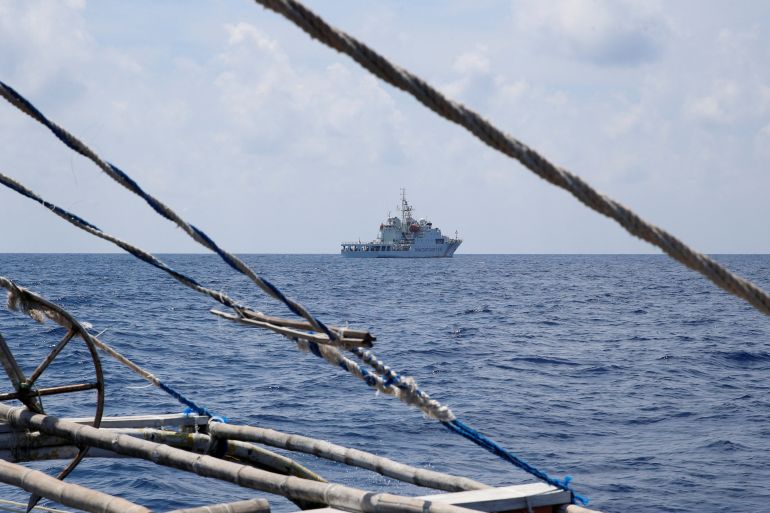 A Chinese coast guard ship seen through rigging on a Philippines fishing boat near Scarborough Shoal in the South China Sea