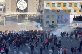 Police officers use tear gas to disperse rioting football fans [All About Ajax/via Reuters]