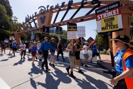 SAG-AFTRA actors and Writers Guild of America writers walk the picket line outside Disney Studios in Burbank, California, July 25, 2023 [File: Mike Blake/Reuters]