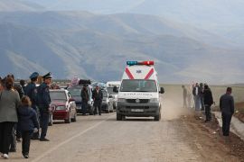 An ambulance drives along a road as refugees from Nagorno-Karabakh region arrive in the border village of Kornidzor, Armenia [Irakli Gedenidze/Reuters]