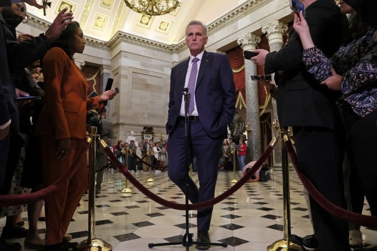 U.S. House Speaker Kevin McCarthy speaks to members of the media as the deadline to avert a government shutdown approaches on Capitol Hill in Washington, U.S., September 26, 2023. Under a domed, ornate ceiling, he stands behind velvet ropes, as reporters hold out their recording devices and ask questions.