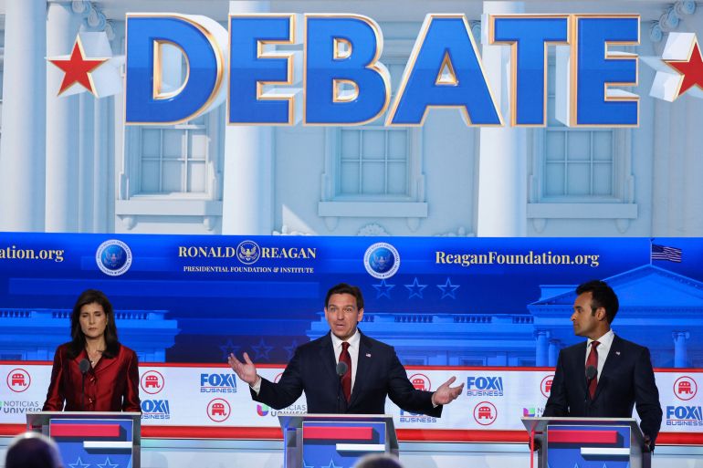 Three of the Republican candidates on stage during the debate. Ron DeSantis is in the centre with his hands out making a point. On his right is Nikki Haley on his left Vivek Ramaswamy