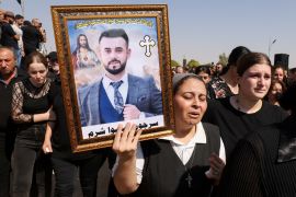 A mourner carries the portrait of a victim during the funeral of victims of the fatal fire at a wedding celebration, in Hamdaniya, Iraq, September 28, 2023 [Ahmed Saad/Reuters]