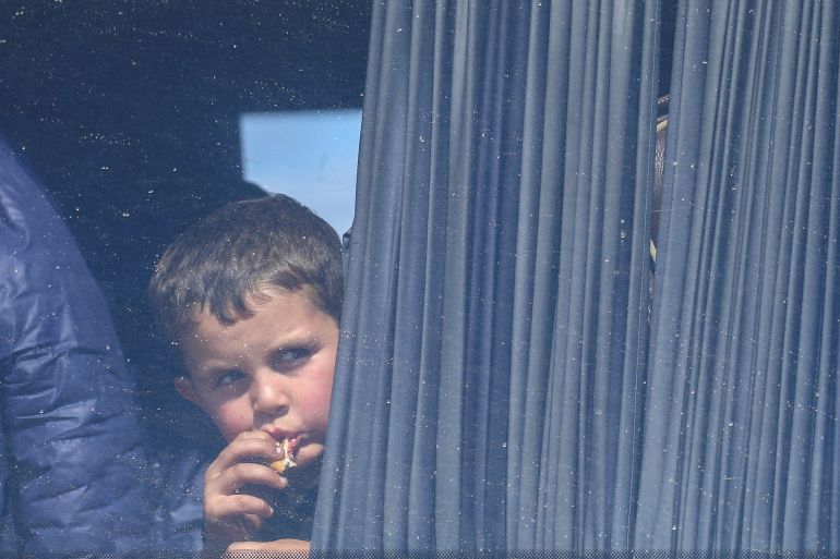 boy looks through a window of a bus used by refugees fleeing Nagorno-Karabakh region upon their arrival in the border village of Kornidzor, Armenia