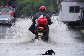 A man rides a motorcycle through flooded streets in the Hole, one of the lowest neighbourhoods in the Brooklyn borough of New York City on September 29, 2023 [Bing Guan/Reuters]