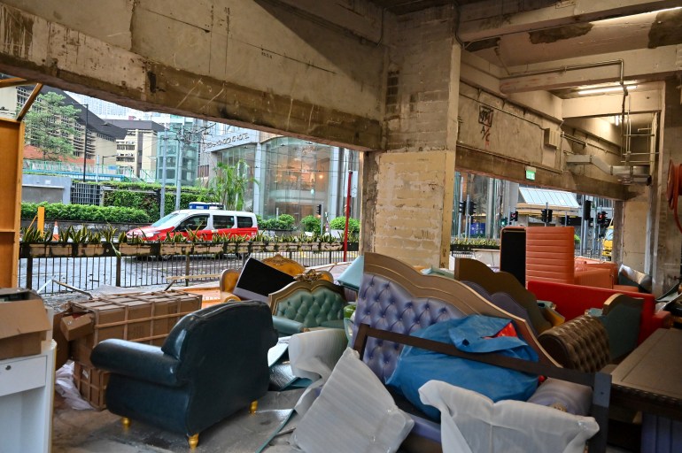 A taxi drives in front of debris of the protection panels of a furniture shop in renovation swept away by Super Typhoon Saola in Causeway Bay in Hong Kong on September 2, 2023. - Typhoon Saola swept across southern China on Saturday after tearing down trees and smashing windows in Hong Kong, although the megacity avoided a feared direct hit from one of the region's strongest storms in decades. (Photo by Mladen ANTONOV / AFP
