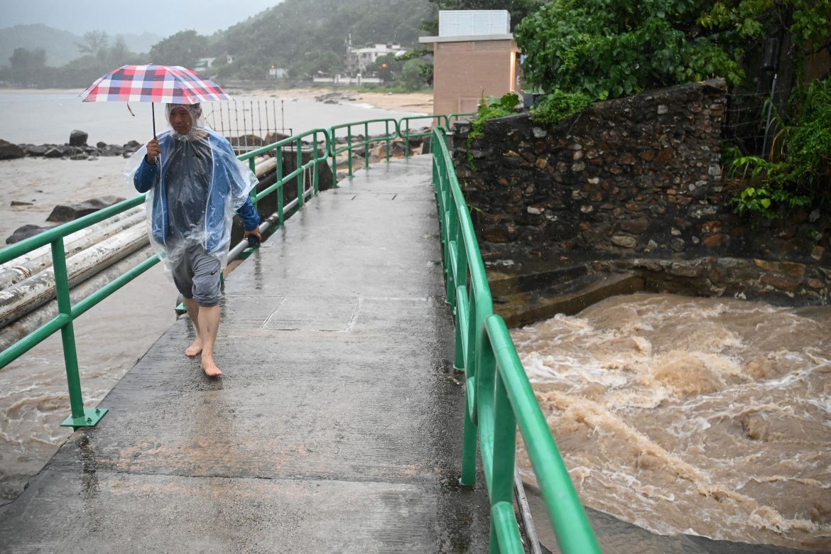 A man walks on a bridge over a swollen river on Lantau Island in Hong Kong