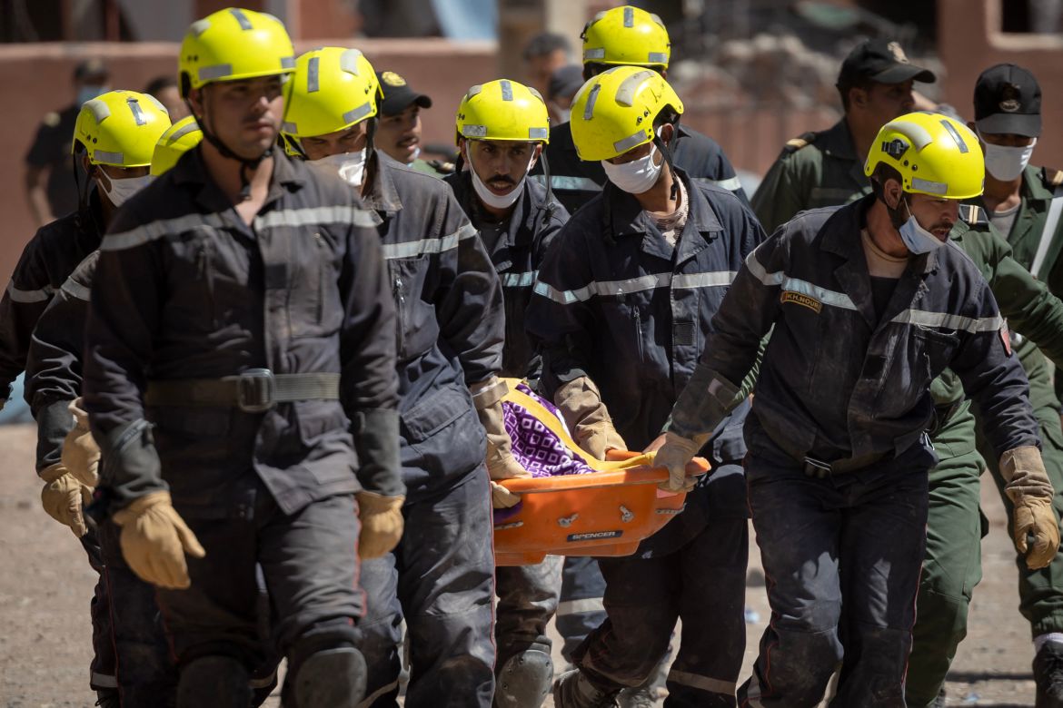 Moroccan rescuers carry a body out of the rubble in Talat N'Yacoub village of al-Haouz province in earthquake-hit Morocco