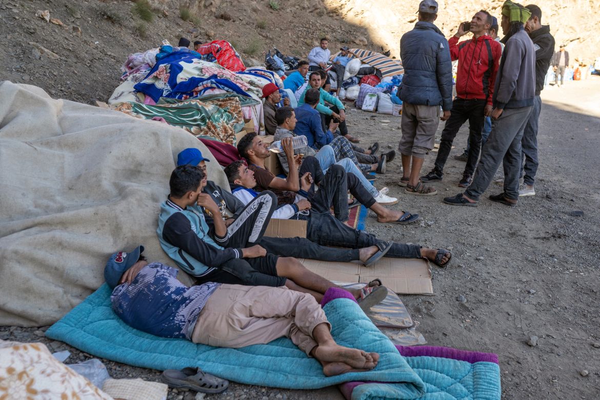 People wait as emergency personnel open a road to their village in the mountainous area of Tizi N'Test, in the Taroudant province, one of the most devastated in quake-hit Morocco