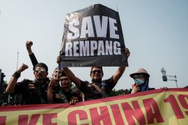 Protesters holding a 'Save Rempang' sign at a rally against the Chinese project