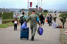 Russian peacekeepers escort ethnic Armenian civilians as they arrive at a Russian military base to receive accommodation near Stepanakert in the Nagorno-Karabakh region [File: Russian Defence Ministry/handout via AFP]