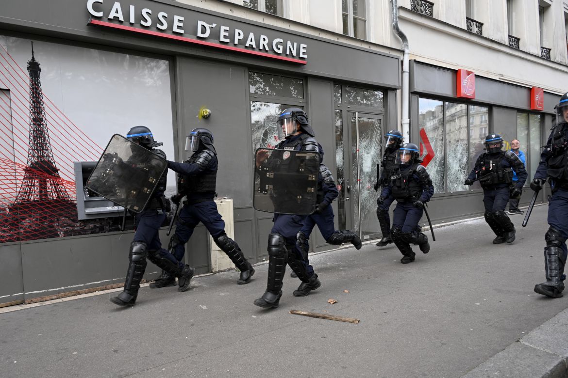 French anti-riot police officers take position during a "united march" against police brutality called