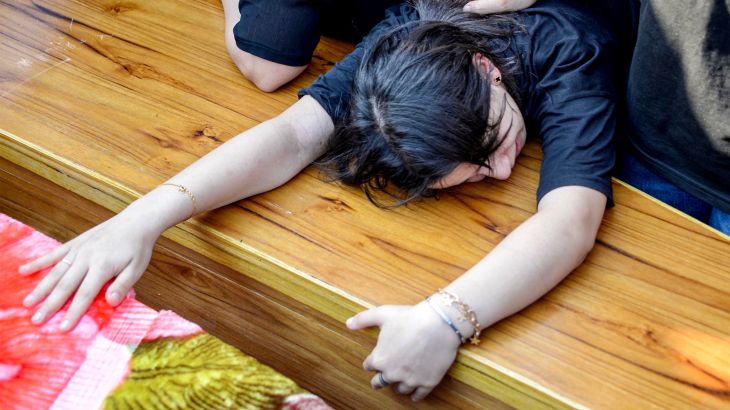 Woman mourns over a coffin.