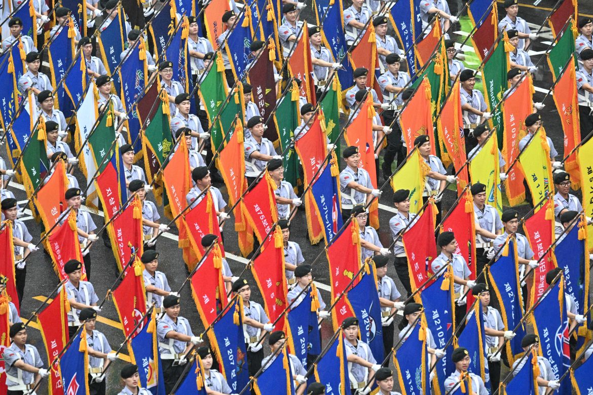Reserve Officers' Training Corps (ROTC) personnel march in the parade They are carrying colourful flags.