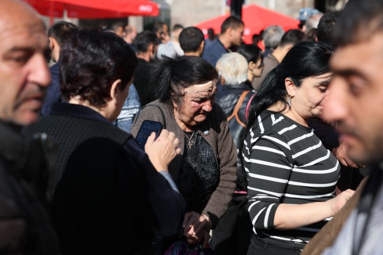 Refugees, including an elderly woman with a head wound she said she got in a car accident as her family fled from Nagorno-Karabakh, wait to pass near a Red Cross registration centre in Goris, on September 27, 2023. - Armenia on September 26, 2023, said 28,120 refugees have so far arrived from Nagorno-Karabakh, a majority ethnic Armenian breakaway enclave defeated in a lightning offensive by Azerbaijan last week. (Photo by ALAIN JOCARD / AFP)