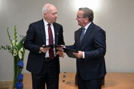 German Defence Minister Boris Pistorius (R) and Israeli Defence Minister Yoav Gallant exchange documents [Tobias Schwarz/AFP]