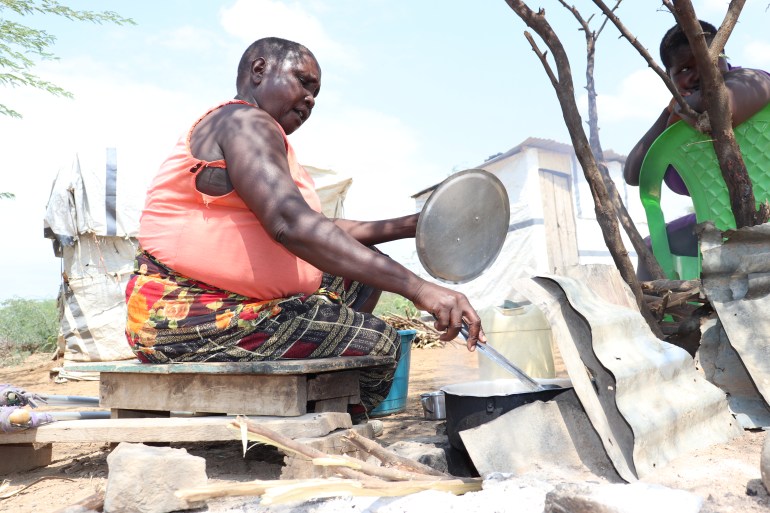59-year-old Ruma Naiweti cooks lunch outside her tent at Kiwanja Ndege