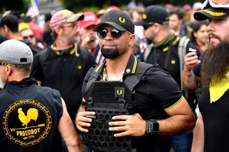 Proud Boys chairman Enrique Tarrio rallies in Portland, Oregon, on August 17, 2019. He wears a black ballcap with the Proud Boys logo, as well as a tactical vest.