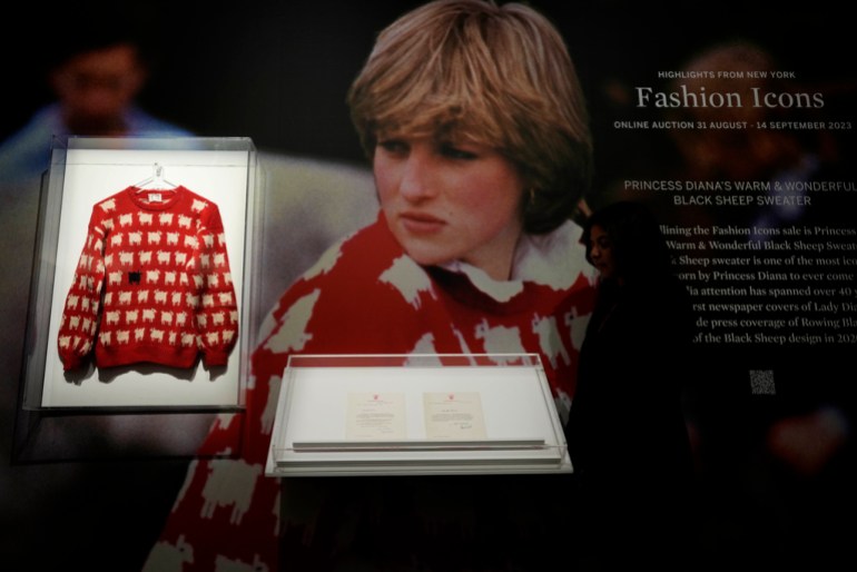 A Sotheby's employee looks at the historic Princess Diana black sheep jumper at the auction house Sotheby's in London, Monday, July 17, 2023. The 'Worn on Several Occasions & Adored by the Fashion Icon' jumper will be on auction headlining Sotheby's inaugural fashion icons sale in New York this September at an Estimate of $50,000 – 80,000, 38,000-61,000 pounds. (AP Photo/Frank Augstein)