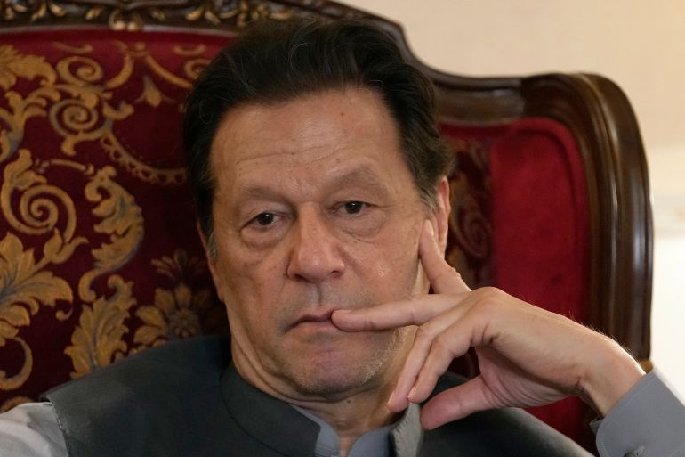 Pakistan's former prime minister Imran Khan listens to a member of media during talk with reporters regarding the current political situation and the ongoing cases against him at his residence