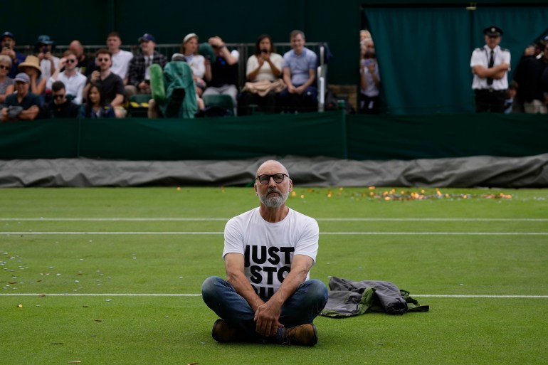 A Just Stop Oil protester sits on Court 18 on day three of the Wimbledon tennis championships