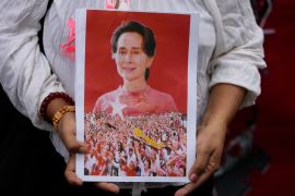 A supporter holding a framed portrait of Aung San Suu Kyi