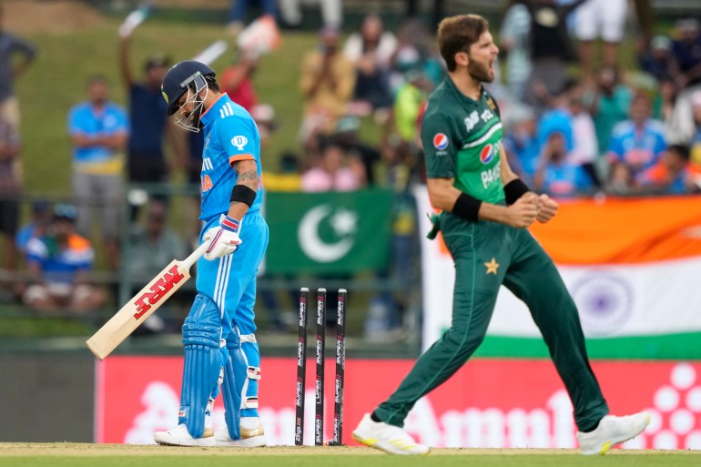 India's Virat Kohli, left, looks down after being bowled out by Pakistan's Shaheen Shah Afrid