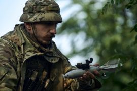A soldier of Ukraine&#39;s 3rd Separate Assault Brigade loads a bomb on a mini-drone near Bakhmut in the Donetsk region, Ukraine, earlier this month [File: Libkos/AP Photo]