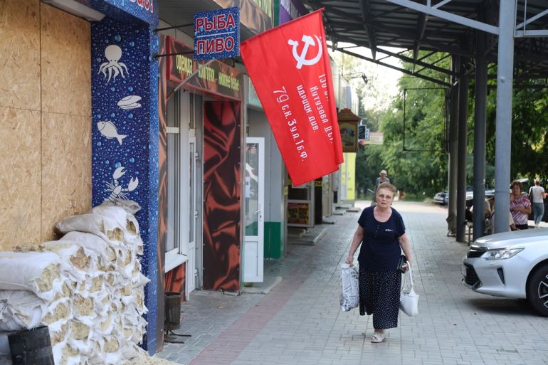 A woman walks past a shop in Donetsk